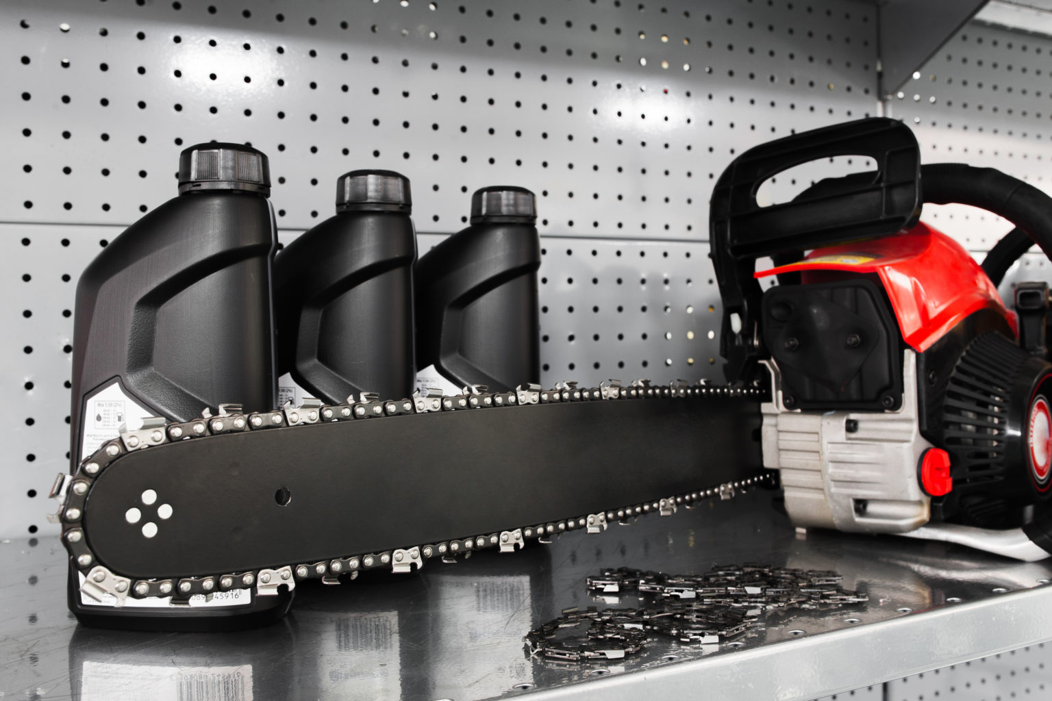 A chainsaw and three jugs of chainsaw lubricant on a shelf