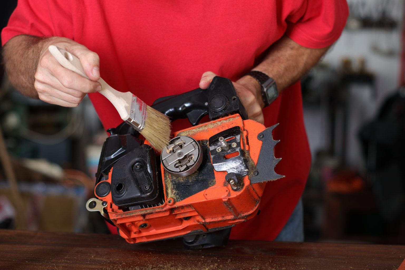 cleaning of the small chainsaw by a person in the garage